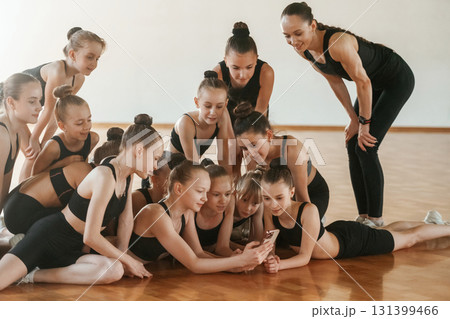 Break time. Group of female kids practicing athletic exercises together indoors 131399466