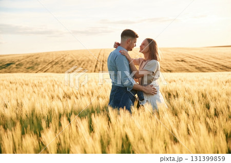 Embracing each other. Lovely beautiful couple are together on the agricultural field Embracing each other. Lovely beautiful couple are together on the agricultural field 131399859