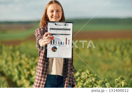 Young woman is on the beautiful agricultural field at daytime Young woman is on the beautiful agricultural field at daytime 131400012
