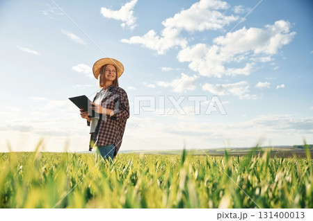 Young woman is on the beautiful agricultural field at daytime Young woman is on the beautiful agricultural field at daytime 131400013