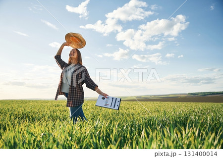 Young woman is on the beautiful agricultural field at daytime 131400014