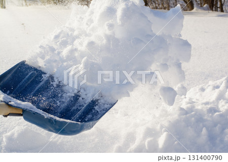 Man shoveling snow in the backyard after night blizzard, removing snow from the yard 131400790