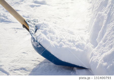 Cleaning snow with a shovel in the countryside after a heavy snowfall 131400793