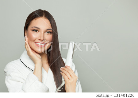 Perfect woman brunette with long straight smooth hairstyle using hair straightener iron 131401226