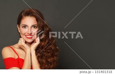 Smiling fashion model woman with shiny skin, wavy hairstyle and red lips makeup on black background Smiling fashion model woman with shiny skin, wavy hairstyle and red lips makeup on black background 131401318