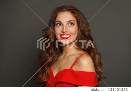 Laughing woman with long hair and make-up on black background. Gorgeous woman with curly hairstyle 131401328