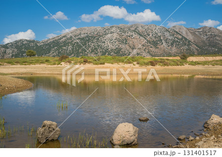 Cretan mountain landscape in Omalos village with mountains reflected in small lake. 131401517