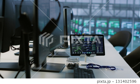 Close up of headphones left by worker on server room PCs used by employees working to ensure minimal downtime. Equipment in data center workplace used for monitoring performance 131402596
