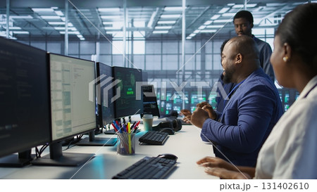 Happy data center employee pleased after successfully installing cybersecurity framework, seeing confirmation after reducing security incidents and enhancing data protection protocols, camera A 131402610