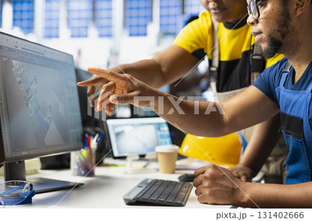 Black team of manufacturing plant employees fixing errors and debugging technical issues, working together in the assembly line of solar panels at the industrial factory. Renewable energy. 131402666