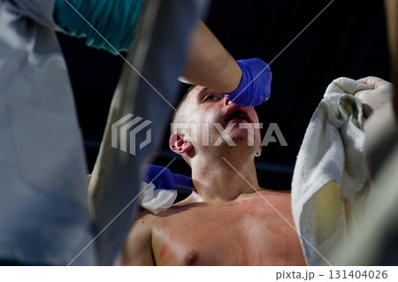 Cornered boxer receives strategic advice from trainer during intense bout. 131404026