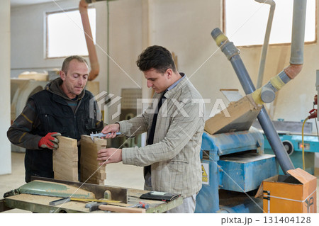 Production Manager Demonstrating Woodcraft Techniques to Employee for Decorative and Residential Items Production Manager Demonstrating Woodcraft Techniques to Employee for Decorative and Residential Items 131404128