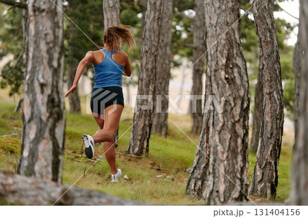 Fearless Woman Conquering Wooden Obstacles in the Dangerous Forest Terrain. Fearless Woman Conquering Wooden Obstacles in the Dangerous Forest Terrain. 131404156