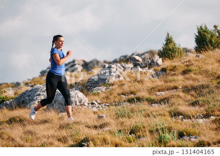 Empowered Runner Embracing Nature's Beauty on a Serene Morning Trail. 131404165