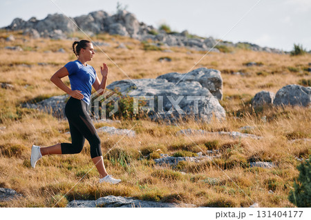 Empowered Runner Embracing Nature's Beauty on a Serene Morning Trail. 131404177
