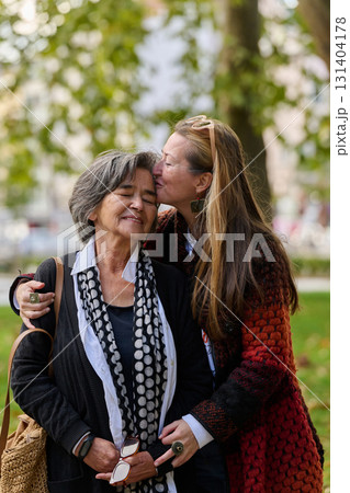 A Heartfelt Embrace: A Daughters Support for Her Mother on a Beautiful Autumn Day. 131404178