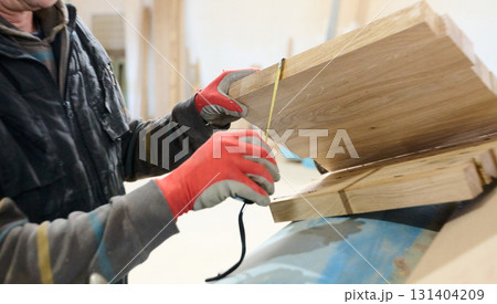 Close Up of Worker Carefully Cutting and Planing Wooden Pieces for Furniture in Wood Industry 131404209