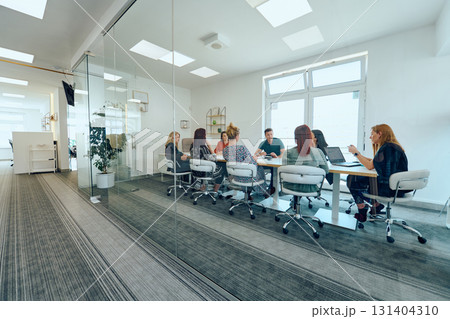 Diverse Business Team Discussing Projects in a Modern Glass Office. 131404310