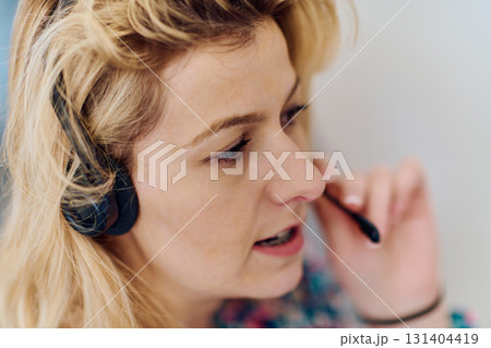 Friendly Call Center Agent Answering Incoming Calls with Headset Providing Remote Customer Service. Friendly Call Center Agent Answering Incoming Calls with Headset Providing Remote Customer Service. 131404419