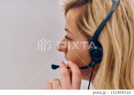 Friendly Call Center Agent Answering Incoming Calls with Headset Providing Remote Customer Service. 131404510