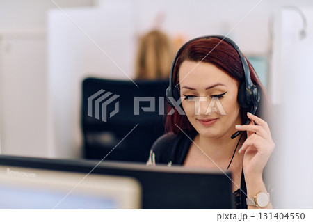 Friendly Call Center Agent Answering Incoming Calls with Headset Providing Remote Customer Service. 131404550