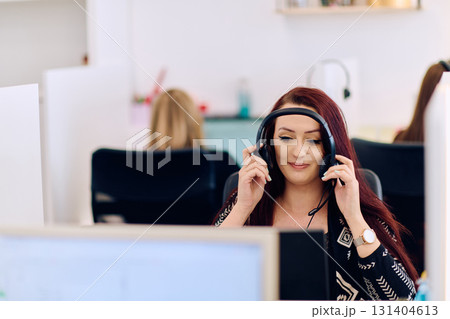 Friendly Call Center Agent Answering Incoming Calls with Headset Providing Remote Customer Service. 131404613