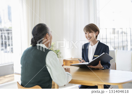 シニア男性と話をするミドルのビジネスウーマン シニア男性と話をするミドルのビジネスウーマン 131404618