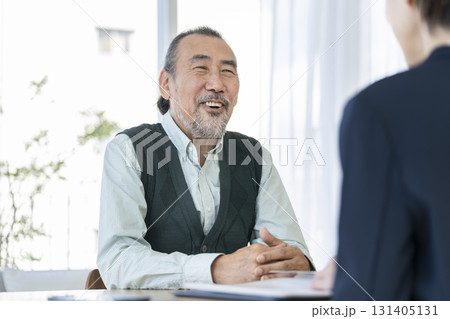 ビジネスウーマンと向き合って話をするシニア男性 131405131