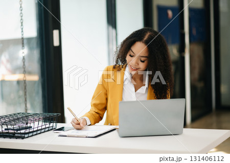 Business woman Talking on the phone and using a laptop at office 131406112
