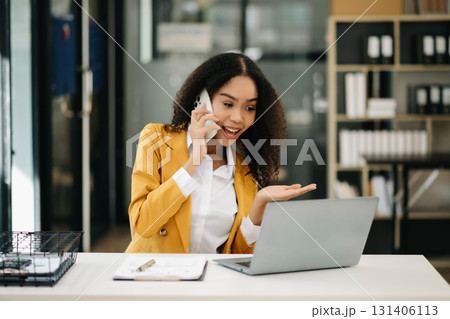 Business woman Talking on the phone and using a laptop at office 131406113