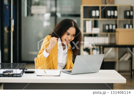 Business woman Talking on the phone and using a laptop at office Business woman Talking on the phone and using a laptop at office 131406114