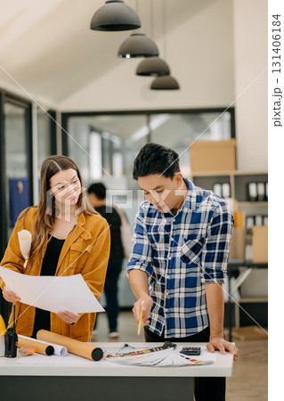 Two colleagues discussing data working and tablet, laptop with architectural project at construction site at desk 131406184