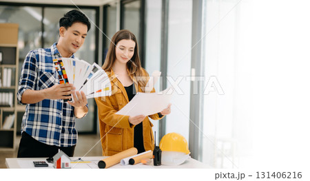 Two colleagues discussing data working and tablet, laptop with architectural project at construction site at desk Two colleagues discussing data working and tablet, laptop with architectural project at construction site at desk 131406216