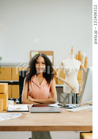 Young entrepreneur working in a creative workspace, surrounded by packaging, boxes 131406312