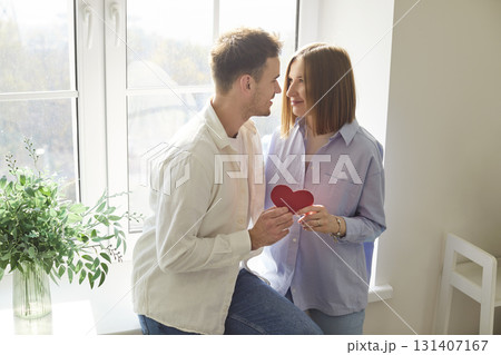 Couple Hugging With A Red Heart Gift For Valentine Day Celebration At Home 131407167