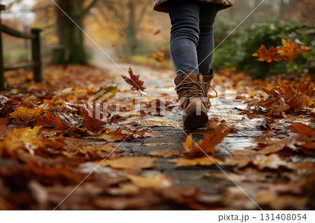 Barefoot child playing in colorful autumn leaves on pathway Barefoot child playing in colorful autumn leaves on pathway 131408054