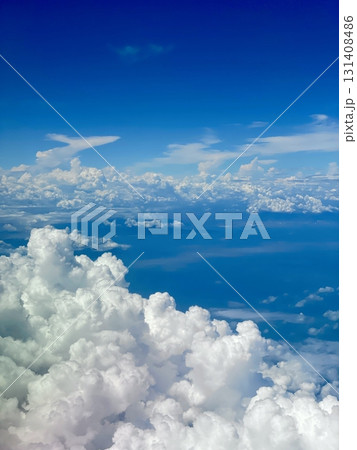 A stunning view through an airplane window, showcasing clear skies and fluffy clouds. The perspective captures the beauty of travel and the freedom of soaring above the earth. A stunning view through an airplane window, showcasing clear skies and fluffy clouds. The perspective captures the beauty of travel and the freedom of soaring above the earth. 131408486