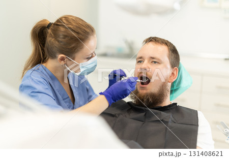 man sits in a chair at an appointment at a dental clinic 131408621