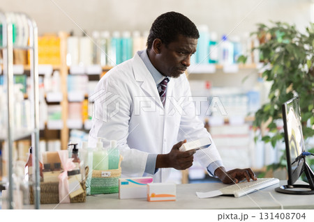 Pharmacist checking stock of medicines, offering to customer at pharmacy Pharmacist checking stock of medicines, offering to customer at pharmacy 131408704