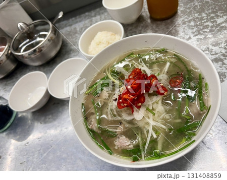 A comforting bowl of salguksu, Korean knife-cut noodles served in a light and savory broth with tender chicken and fresh vegetables. Perfect for a warm, satisfying meal. A comforting bowl of salguksu, Korean knife-cut noodles served in a light and savory broth with tender chicken and fresh vegetables. Perfect for a warm, satisfying meal. 131408859