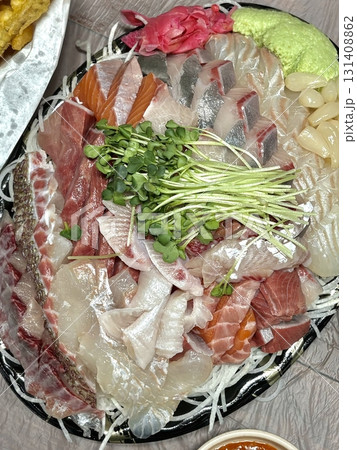 Fresh and delicate sashimi slices, beautifully presented with vibrant colors and perfect cuts. This traditional Japanese delicacy highlights the pure flavors of premium seafood. 131408862