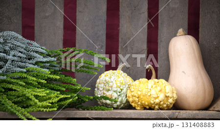 Autumn Harvest Display With Pumpkins and Greenery Against Rustic Wooden Backdrop Centerpiece Decor Autumn Harvest Display With Pumpkins and Greenery Against Rustic Wooden Backdrop Centerpiece Decor 131408883