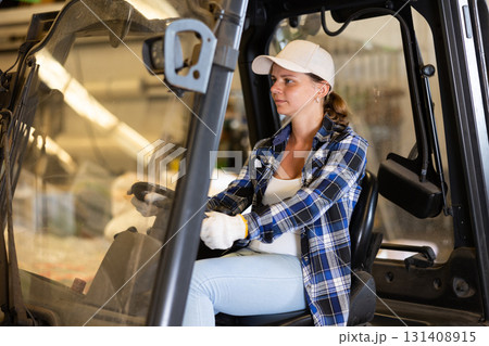 Woman driving fork lift in storehouse Woman driving fork lift in storehouse 131408915
