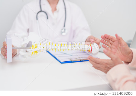 Elderly Patient consulting Doctor with Spine anatomy for Spinal Cord Disorder and disease, Back pain, Lumbar, Sacral pelvis, Cervical neck, Thoracic, Coccyx, Orthopedist, chiropractic, Office Syndrome Elderly Patient consulting Doctor with Spine anatomy for Spinal Cord Disorder and disease, Back pain, Lumbar, Sacral pelvis, Cervical neck, Thoracic, Coccyx, Orthopedist, chiropractic, Office Syndrome 131409200