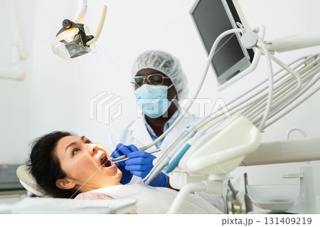 Dentist examining oral cavity of woman in dental clinic 131409219