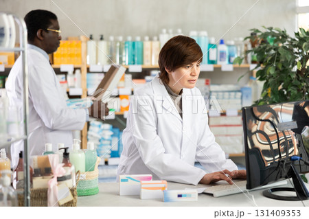 Female pharmacist working at computer in pharmacy Female pharmacist working at computer in pharmacy 131409353