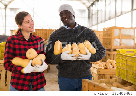 Portrait of two smiling farmers with pumpkins 131409469