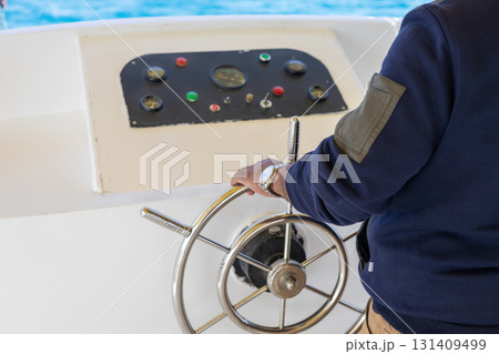 Boating adventure with steering wheel navigation on open waters 131409499