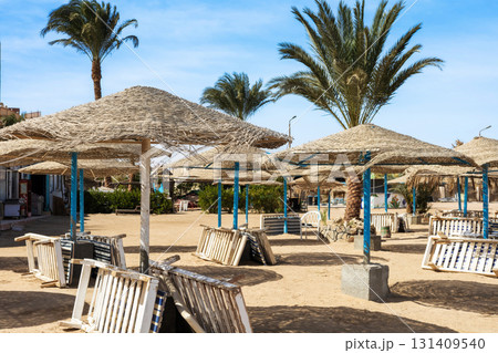 Serene beachfront cabana retreat with rustic wooden sun loungers and palm trees 131409540