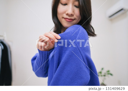 ブルーのニットをクローズアップして紹介するファッション系インフルエンサー ブルーのニットをクローズアップして紹介するファッション系インフルエンサー 131409629